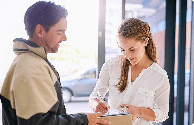 Courier delivering a package to a smiling woman at her doorstep